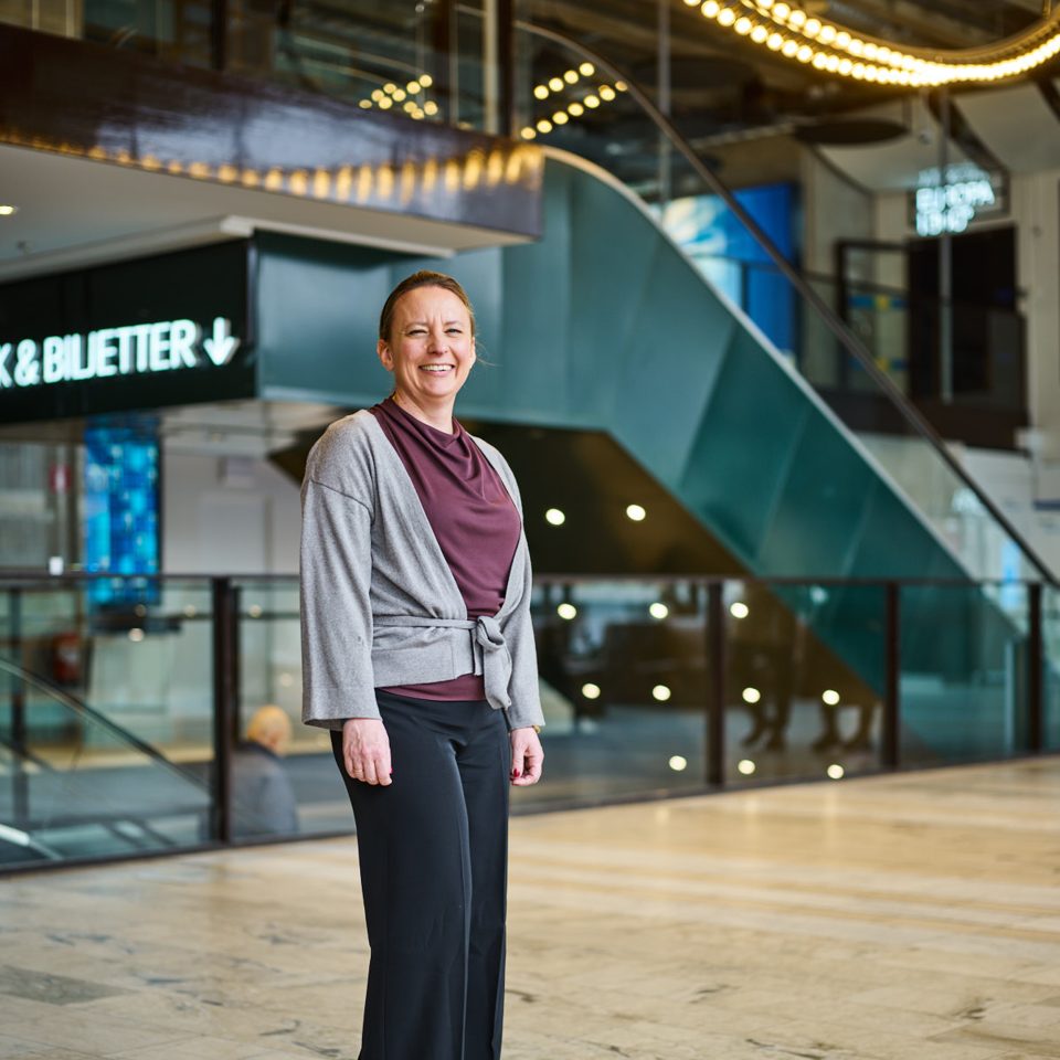 Petra Ehle, partner of Influence People, a Newground Company, standing in a public indoor environment. The intersection of business and people in transformation.